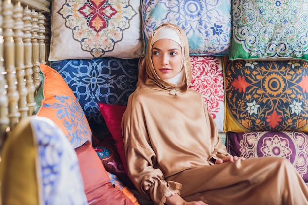 Arabian young muslim woman sitting in a cafe.