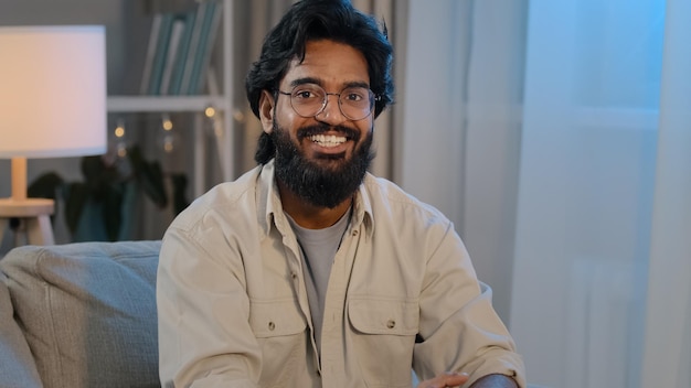 Arabic bearded surprised indian shocked man in glasses at home looking at camera says wow wide