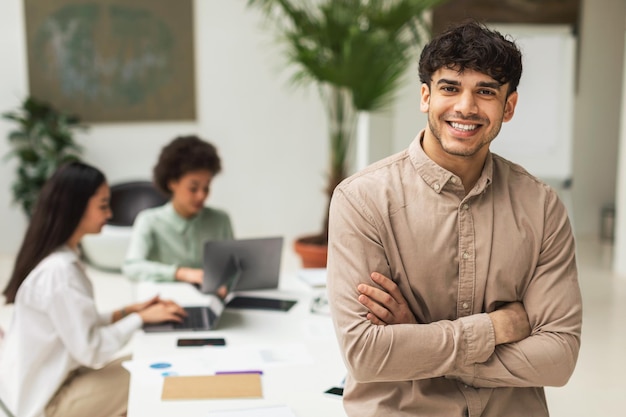 Arabic business guy posing standing at corporate meeting in office