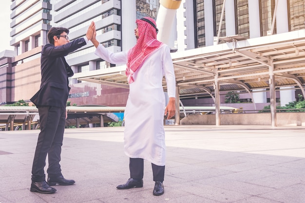 Arabic businessman giving an high five to his business partner, on construction site