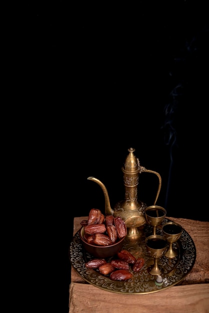 Arabic coffee and dates set up black background