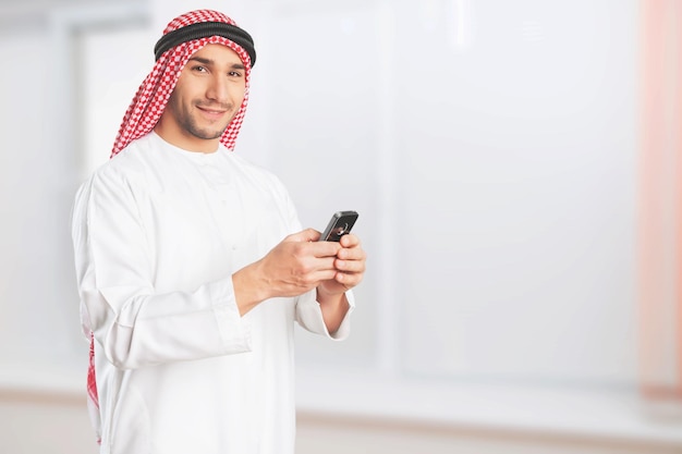 Arabic corporate business man looking at mobile phone and smiling