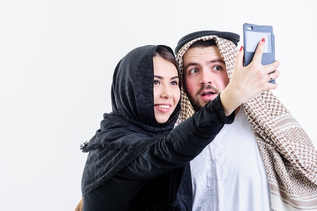 Arabic couple take self pictures with sell phone.Selfie.