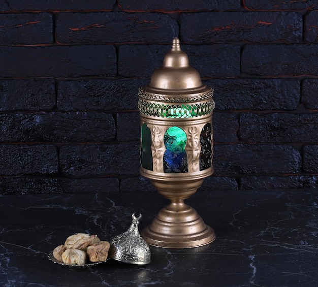 arabic lamp and dried fruits on black background