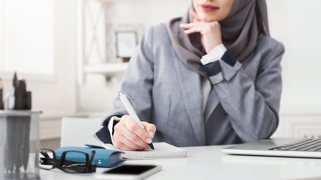 Arabic young woman at office with phone and documents