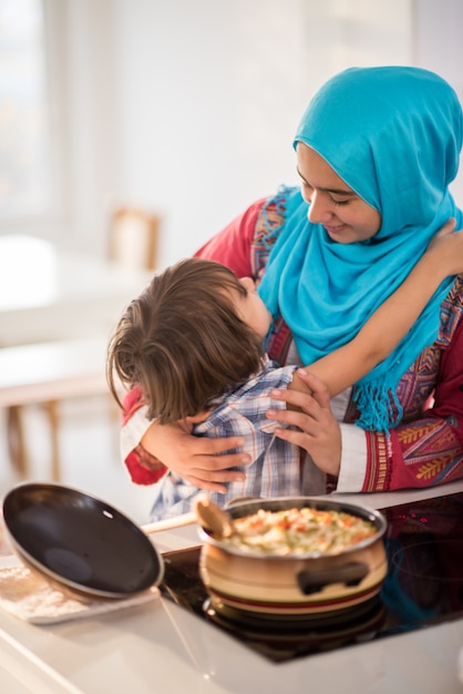 Arabic young woman with little kid in kitchen