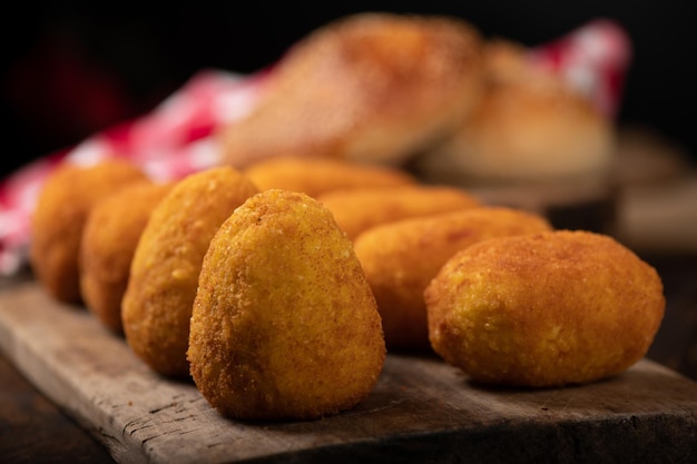 Arancini rice balls Fried rice balls in paper on brown wooden background Snack street food