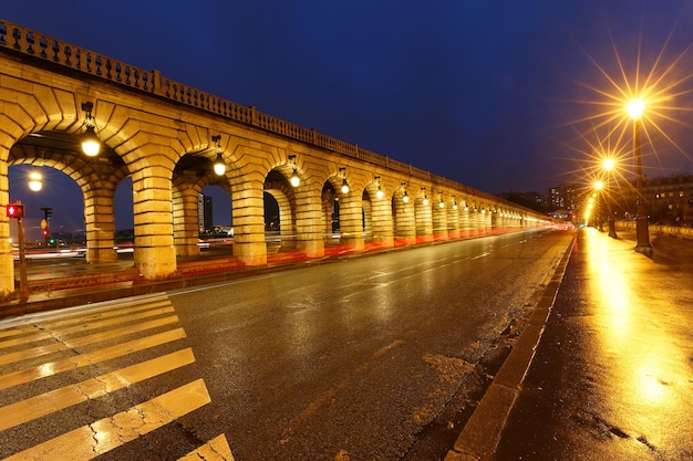 The arcades of Bercy bridge at rainy night Paris france