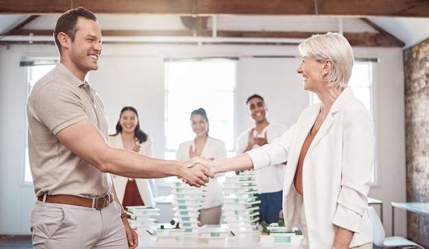 Photo architect business handshake and partnership meeting of people in agreement for architecture plan at the office happy senior woman and young man shaking hands in collaboration at work for teamwork