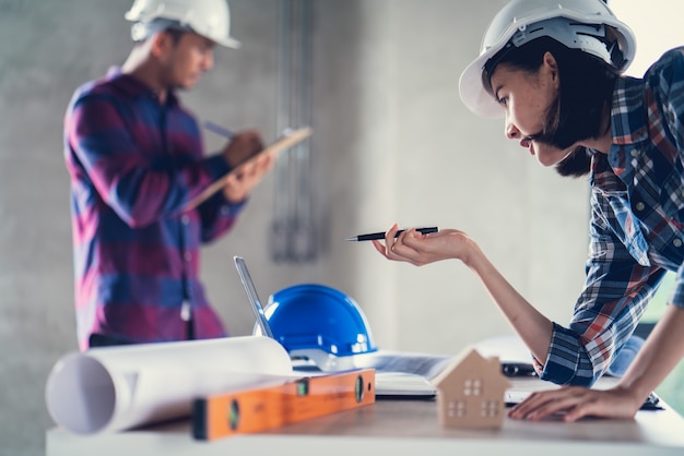 Architect & Engineer working drawing document about project planning and progress of work schedule on the home building construction site