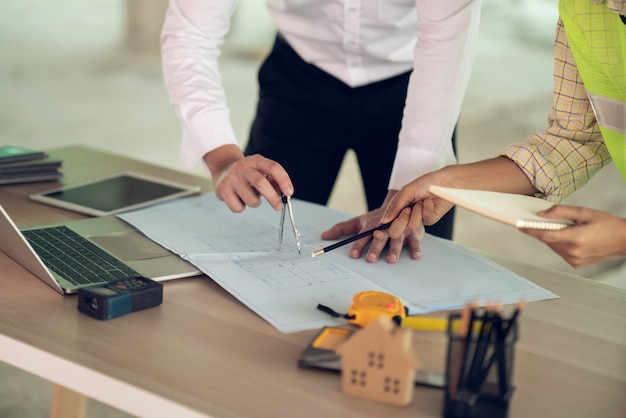 Architect & Engineer working drawing document about project planning and progress of work schedule on the home building construction site