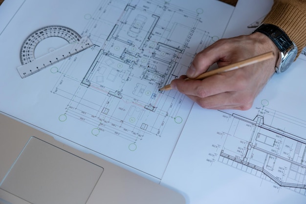 Architect hands drawing blueprint sketching design of house working on project making architectural construction building in office