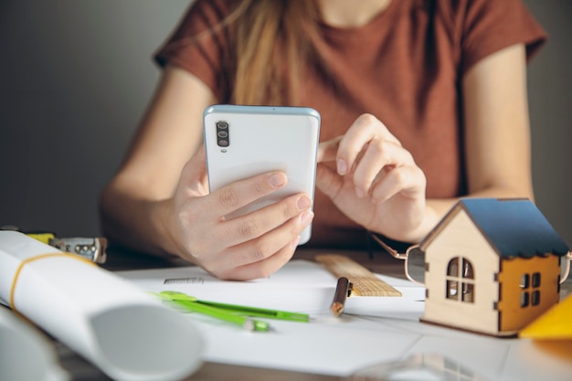 Architect holding phone in front of desk