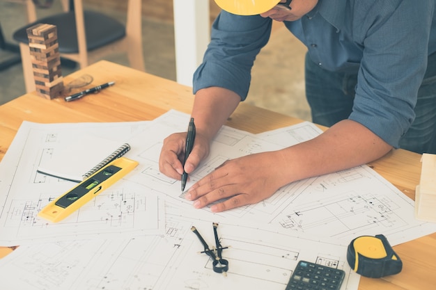 Architect or planner working on drawings for construction plans at a table