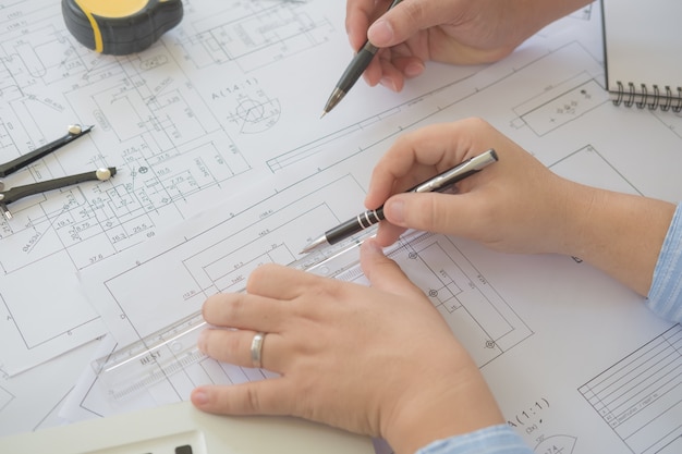 Architect or planner working on drawings for construction plans at a table