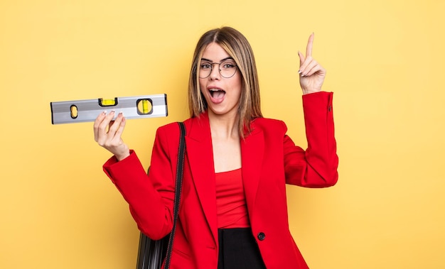 Architect woman feeling like a happy and excited genius after realizing an idea and holding a level balance