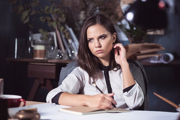 Architect woman working on drawing table in office