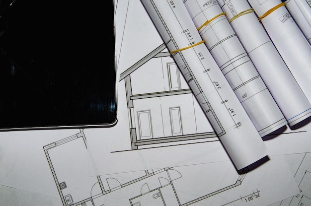 Architects work table with technical drawings and tablet computer