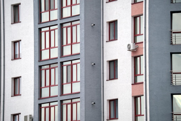 Architectural details of modern high apartment building facade with many windows and balconies