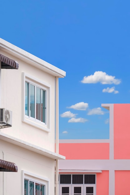 Architecture background of white and pink modern buildings against blue sky in vertical frame