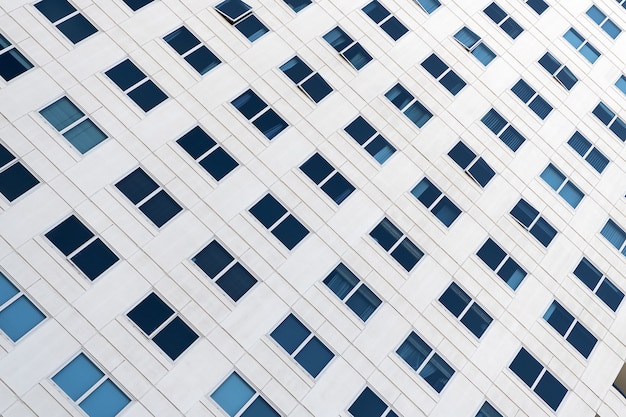 Architecture that speaks. Architectural construction detail. Modern urban architecture. Structural element on diagonal. Building part of office block. Facade with windows.