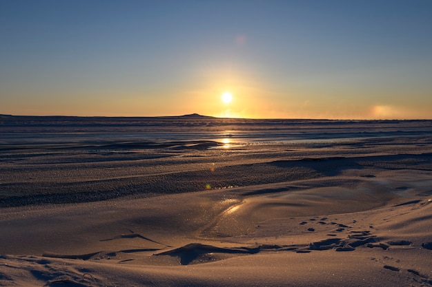 Arctic landscape in winter time. Small river with ice in tundra