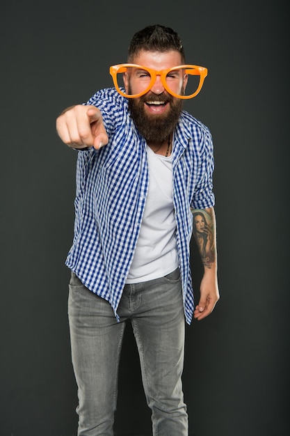 Are you going to the party. Party man pointing finger on grey background. Bearded man wearing party glasses. Preparing a cool party.