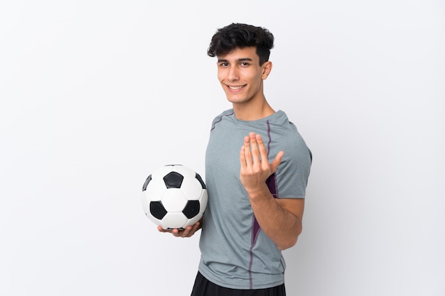 Argentinian football player man over isolated white wall inviting to come with hand. Happy that you came