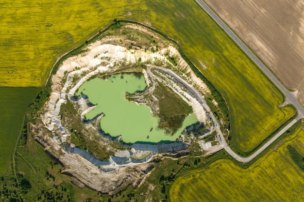 Ariel top view of an old flooded lime quarry with turquoise water