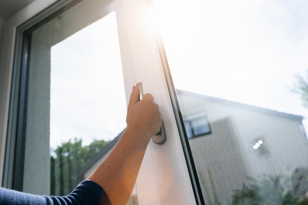 Arm open white plastic window with sunlight