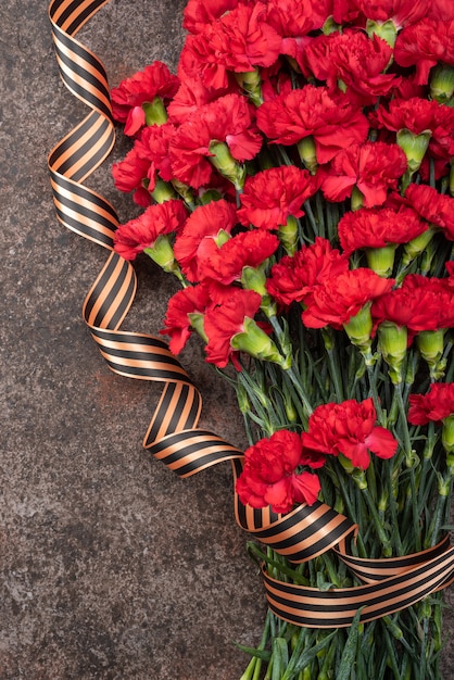 Armful carnations on dark background with ribbon