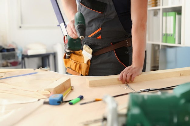 Arms of worker using electric drill