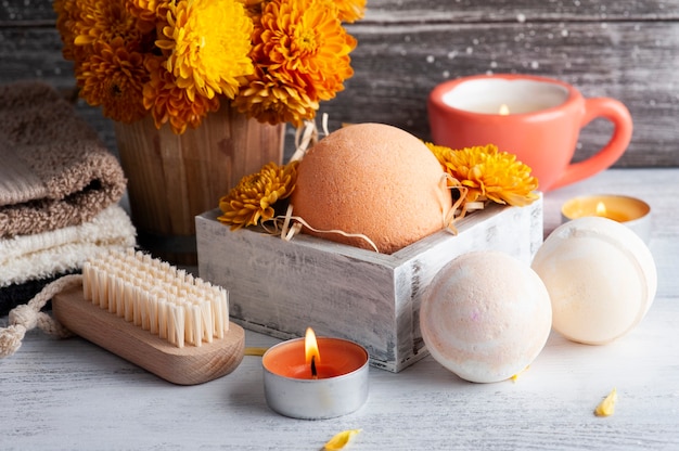 Aroma bath bombs in spa composition with orange flowers and towels