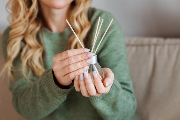 Aroma diffuser for home in the woman's hands with nude manicure