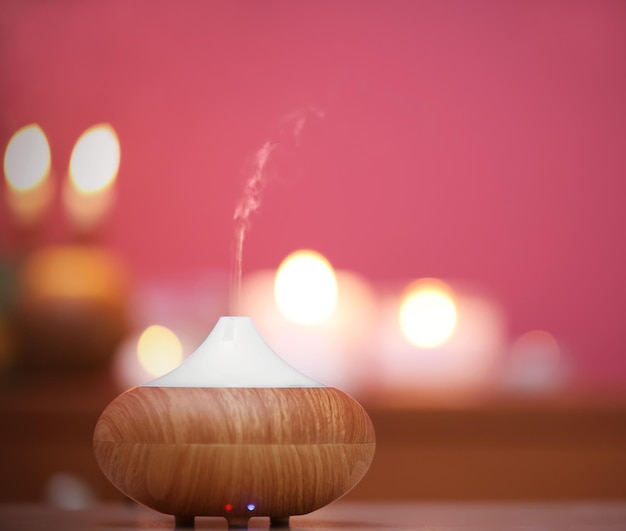 Aroma oil diffuser on blurred candlelight background