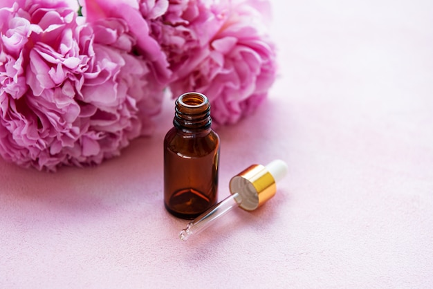 Aromatherapy essentials oils and pink peonies