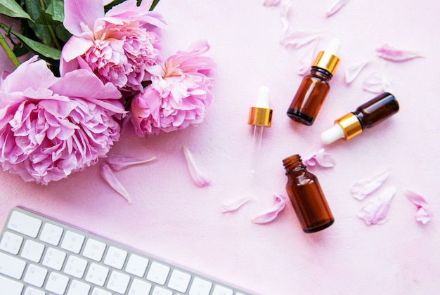 Aromatherapy essentials oils and pink peonies