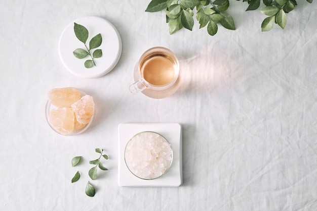 Aromatherapy. Small glass bottles with cosmetic oils. Bath salt. Fresh leaf. Objects for spa procedures on white background oil, leaf.