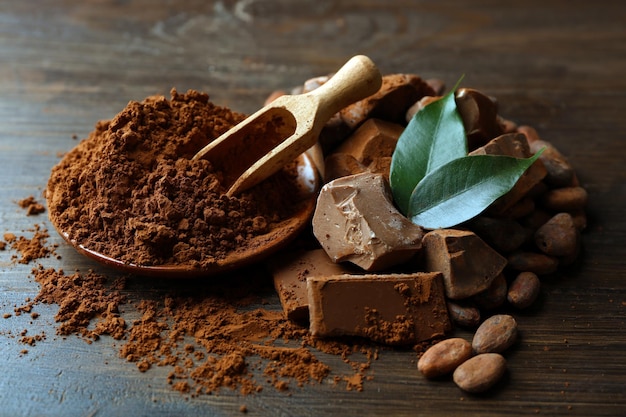 Aromatic cocoa and chocolate on wooden background close up