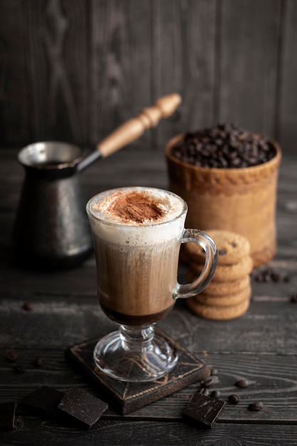 Aromatic coffee with cream and chocolate on a dark rustic background