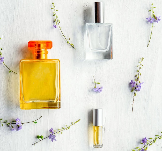 Aromatic Perfume bottles set and flower on the white wooden desk on at wooden background