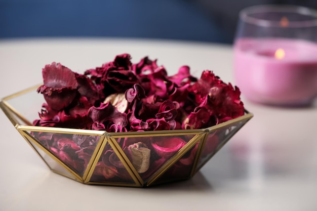 Aromatic potpourri of dried flowers in glass bowl on table indoors closeup