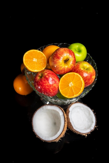 Arrangement with fruits on a shiny black surface with black background