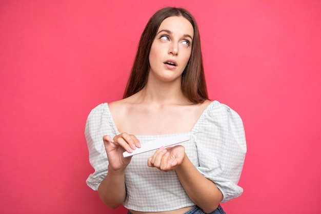 Arrogant facial expression girl rolled her eyes, pink background, emotions