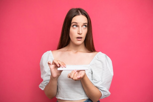 Arrogant facial expression girl rolled her eyes, pink background, emotions