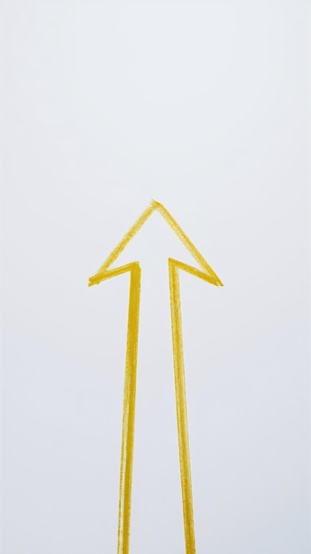 Arrow drawn with yellow crayon on white background