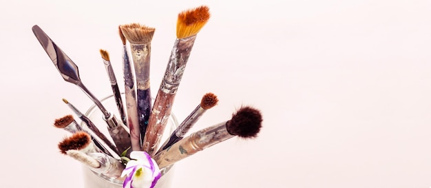 Art brushes and flowers in glass Selective focus banner format