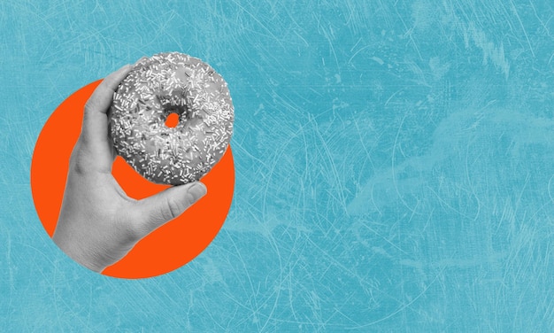 Art collage hand holding donut on blue background with copy space The concept of sugar harm