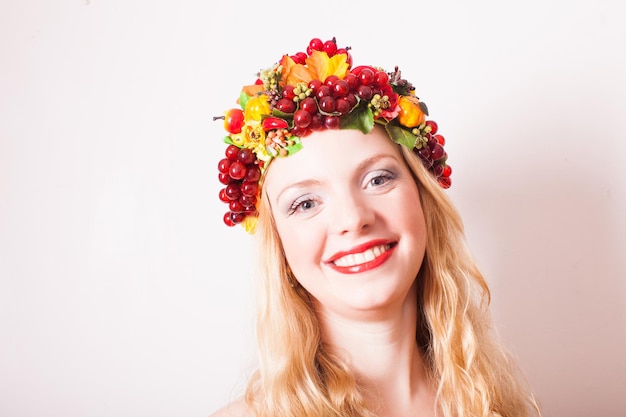 Art creative portrait of blonde woman in autumnal wreath. Conceptr of mother Earth