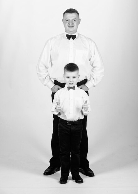 Art director father and son in formal suit little boy with dad businessman family day esthete male fashion happy child with father business meeting party tuxedo style art director concept